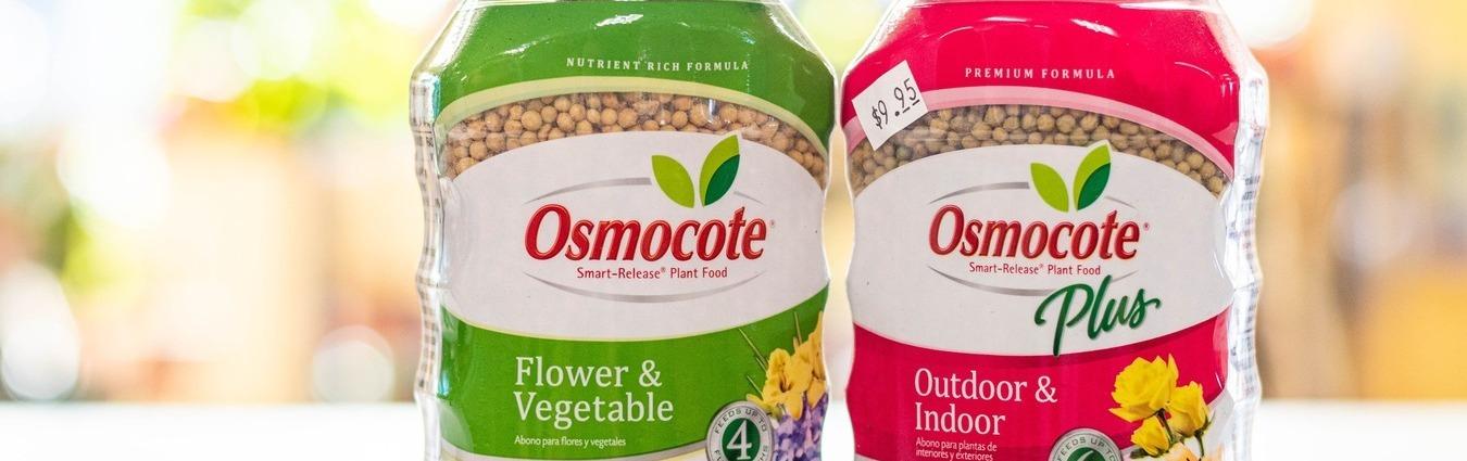 june_blog_banner_RV3 Two Osmocote plant food containers are shown side by side. The green label is for Flower & Vegetable, and the pink label is for Outdoor & Indoor Plus. Both containers have visible plant food pellets inside.